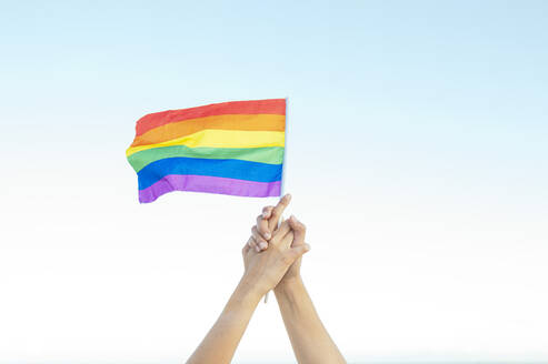 Lesbisches Paar hält Regenbogenflagge - JCMF02128