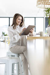 Female professional using digital tablet while sitting in office - PESF02962