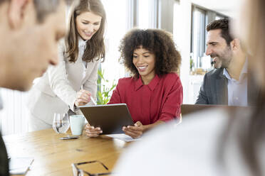 Geschäftsfrau nutzt digitales Tablet mit Kollegen in einer Besprechung im Büro - PESF02999