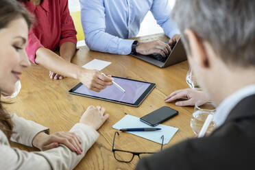 Geschäftsleute verwenden während einer Besprechung ein digitales Tablet auf dem Tisch - PESF03006