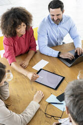 Berufstätige, die im Büro über ein digitales Tablet arbeiten - PESF03008
