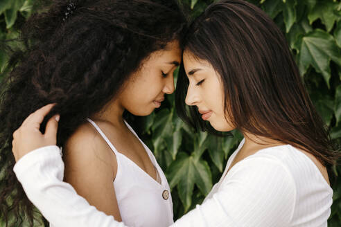 Young women with eyes closed by plants - TCEF01996