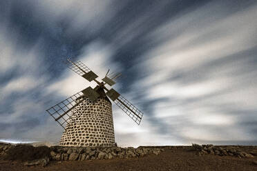 Clouds in the starry sky over a traditional windmill, La Oliva, Fuerteventura, Canary Islands, Spain, Atlantic, Europe - RHPLF20400