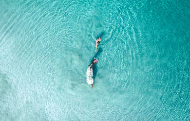 Luftaufnahme der Person Schwimmen und Spielen mit Pferd in den blauen Ozean Wellen, Tierra Bomba, Kolumbien - AAEF09543