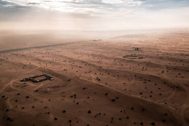 Luftaufnahme von Lichtstrahlen leuchten auf Sanddünen und Hauptstraße der arabischen Wüste in Dubai, UAE - AAEF09552