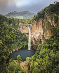 Luftaufnahme eines großen Wasserfalls und eines Sees, umgeben von üppigem grünen Wald in Rolante, Rio Grande Do Sul, Brasilien. - AAEF09684