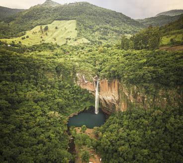 Luftaufnahme eines großen Wasserfalls und eines Sees, umgeben von üppigem grünen Wald in Rolante, Rio Grande Do Sul, Brasilien. - AAEF09685