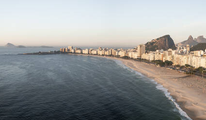 Panorama-Luftaufnahme der Copacabana Beachfront bei Sonnenaufgang mit Bergwut im Hintergrund, Rio De Janeiro, Brasilien. - AAEF09691