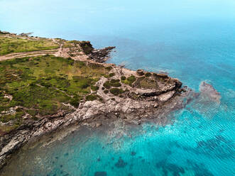 Luftaufnahme einer spektakulären, von einer Klippe umschlossenen Bucht mit einem antiken Wachturm aus dem Mittelalter in Porto Ferro, Sardinien, Italien. - AAEF09740