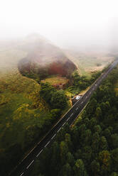 Aerial view of a car along a scenic road crossing the countryside on Pico Island, Azores, Portugal. - AAEF09771