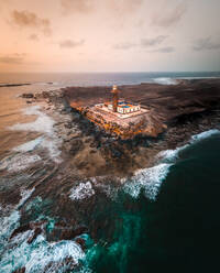 Aerial view of a lighthouse along the wild coastline in Punta de Jandia, Fuerteventura island, Canary islands, Spain. - AAEF09795