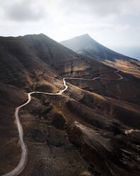 Luftaufnahme einer Panoramastraße, die über einen Berg in der Nähe von Cofete, Insel Fuerteventura, Kanarische Inseln, Spanien, führt. - AAEF09796
