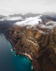 Luftaufnahme einer schönen wilden Küste mit Bergen im Hintergrund in der Nähe von Tesarte, Gran Canaria, Kanarische Inseln, Spanien. - AAEF09810