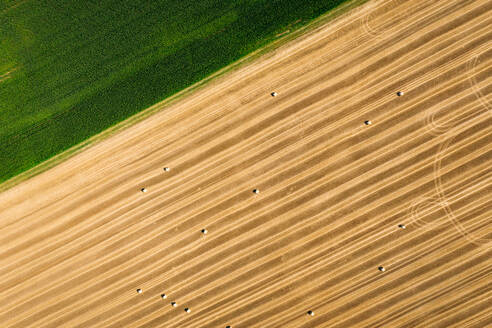 Abstrakte Luftaufnahme von Strohballen auf einem Feld neben einer grünen Wiese in Schernberg, Deutschland. - AAEF09852
