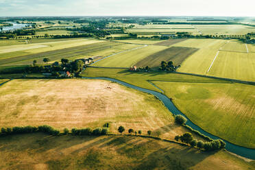 Luftaufnahme eines Flusses, der durch das idyllische Ackerland in IJsselstein, Utrecht, Niederlande, fließt. - AAEF09908