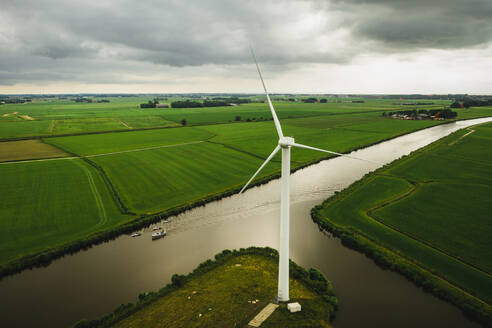 Luftaufnahme von Solarpanel-Booten, die durch das Ackerland in Harlingen, Friesland, Niederlande, fahren. - AAEF09933