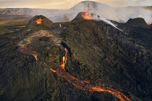 Luftaufnahme von Lava, die den Bergrücken hinunterfließt, Blick auf einen Lavastrom, der aus den Kratern in Grindav√≠k, Südliche Halbinsel, Island, fließt. - AAEF09935