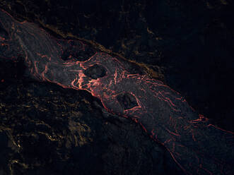 Aerial view of lava streaming down the mountain ridge, view of a river of lava flowing from the craters in Grindav√≠k, Southern Peninsula, Iceland. - AAEF09948