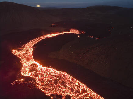 Aerial view of a river of magma and lava streaming down the volcano at night in Grindav√≠k, Southern Peninsula, Iceland. - AAEF09951