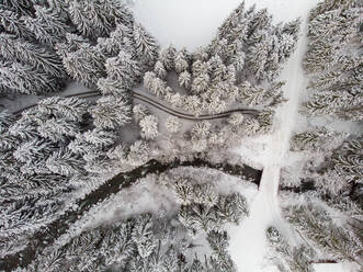 Aerial view of river and walking path covered in snow in winter, Valais, Switzerland. - AAEF10029