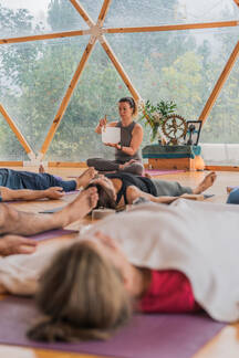 Relaxed people lie in shavasana with closed eyes on yoga mat while