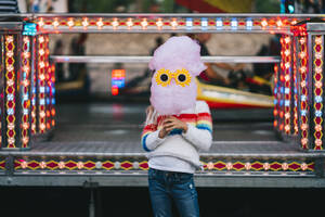 Little girl holding a cotton candy with funny sunglasses in front of her face - ADSF27394