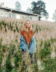 Schöne Frau schaut in die Kamera auf unscharfem Hintergrund einer wunderschönen blühenden Wiese in Lappland - ADSF27436