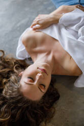 From above beautiful young woman resting on grey stone floor - ADSF27463