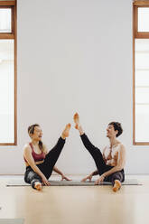 Lachendes Paar bei einer Yoga-Sitzung im Schulungsraum - ADSF27504