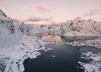 Drone Blick auf Häuser der Stadt und Brücken in der Nähe hoher Hügel an der Küste des Meeres im Winter in Arctic Island - ADSF27515