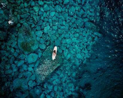 Luftaufnahme einer Person im Kajak, umgeben von kristallklarem Wasser in Caminia, Kalabrien, Italien. - AAEF10037