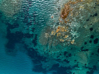 Luftaufnahme einer Lagune mit farbenfrohem und kristallklarem Wasser entlang der Küste bei Santa Maria La Palma, Sardinien, Italien. - AAEF10048