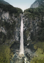 Luftaufnahme eines majestätischen steilen Wasserfalls inmitten eines üppigen Waldes in Cevio, Tessin, Schweiz. - AAEF10059