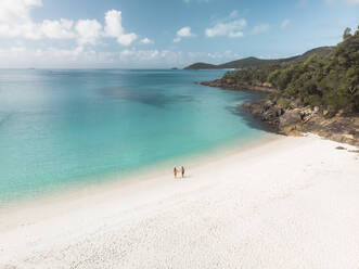 Luftaufnahme eines spazierenden, Händchen haltenden Paares am Strand von South Whitehaven, Queensland, Australien. - AAEF10106