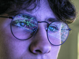 Teenage boy with graph reflection on eyeglasses - ABRF00905