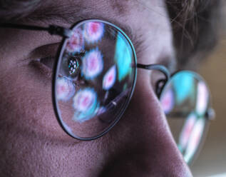 Male scientist wearing eyeglasses with reflection of virus - ABRF00908