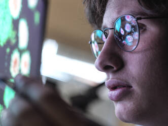 Male expert examining Coronavirus cells on computer monitor in laboratory - ABRF00909