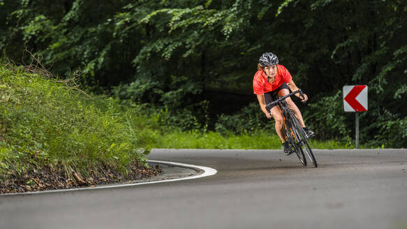 Sportlerin beim Training auf dem Rennrad im Wald - STSF03007