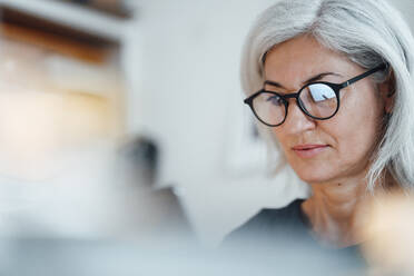 Businesswoman wearing eyeglasses working at office - JOSEF05035