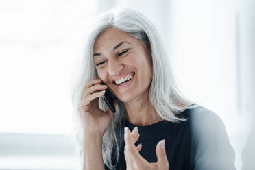 Smiling businesswoman talking on smart phone at office - JOSEF05051