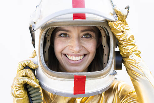 Lächelnde junge Frau mit braunen Augen, die einen Weltraumhelm trägt - DAMF00858