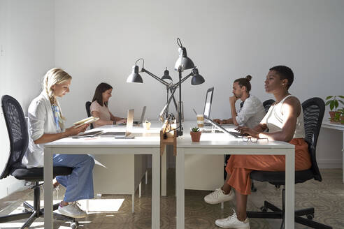 Männliche und weibliche Berufstätige arbeiten am Schreibtisch im Büro - VEGF04684