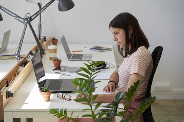 Geschäftsfrau arbeitet am Schreibtisch im Büro - VEGF04711