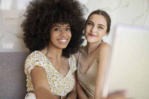 Junge multiethnische Freundinnen machen ein Selfie zu Hause - JCCMF03227