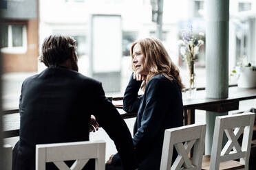 Senior blonde weibliche professionelle Austausch von Ideen während der Diskussion mit Geschäftsmann im Café - JOSEF05159