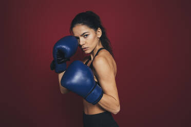 Confident female sportsperson in boxing gloves - OYF00406