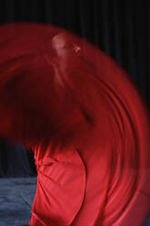 Junge Frau mit Make-up in roter und schwarzer Kleidung, die einen traditionellen spanischen Tanz aufführt und dabei wegschaut - ADSF27651