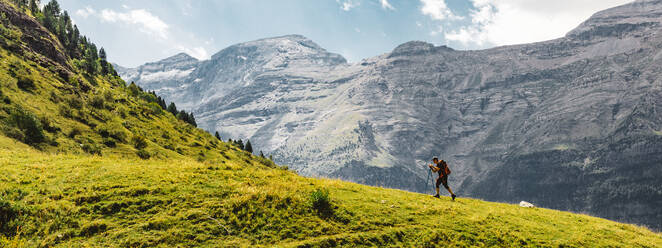 Panoramaseitenansicht von nicht erkennbaren Männern beim Wandern auf einem grünen Berg in den Dolomiten, Italien - ADSF27697