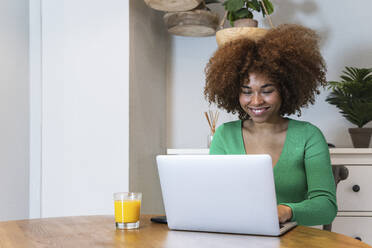 Afro-Geschäftsfrau mit Laptop im Home-Office - PNAF02064