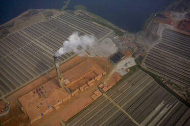 Aerial view of chimneys kilns from brick factory surrounding the area along Dhaleshwari river near Keraniganj township, Dhaka, Bangladesh. - AAEF10401